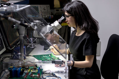 Une étudiante de l'ÉTS en ingénierie est supervisé par un professeur titulaire d'une chaire de recherche dans le cadre de son stage de reherche en laboratoire. 