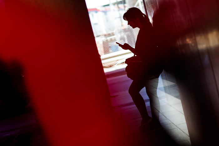 une femme regardant son téléphone portable dans les couloirs du campus de l'ÉTS