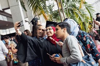 Une famille fière de sa nouvelle diplômée en train de prendre un égoportrait