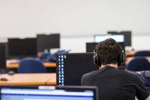 un étudiant dans une salle de classe avec des ordinateurs