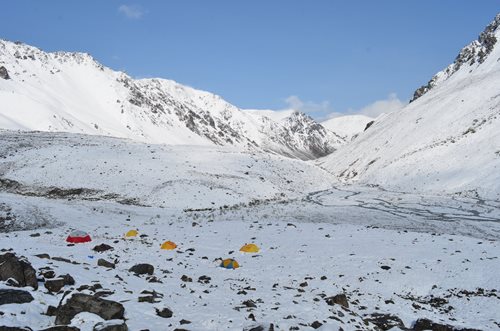 Snow-covered Yukon mountains with campsites.