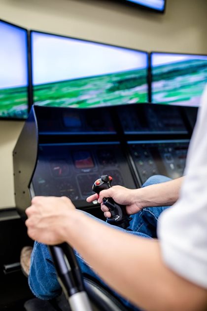 Un homme utilise un simulateur de vol au Laboratoire des technologies spatiales, systèmes embarqués navigation et avionique de l'ÉTS.