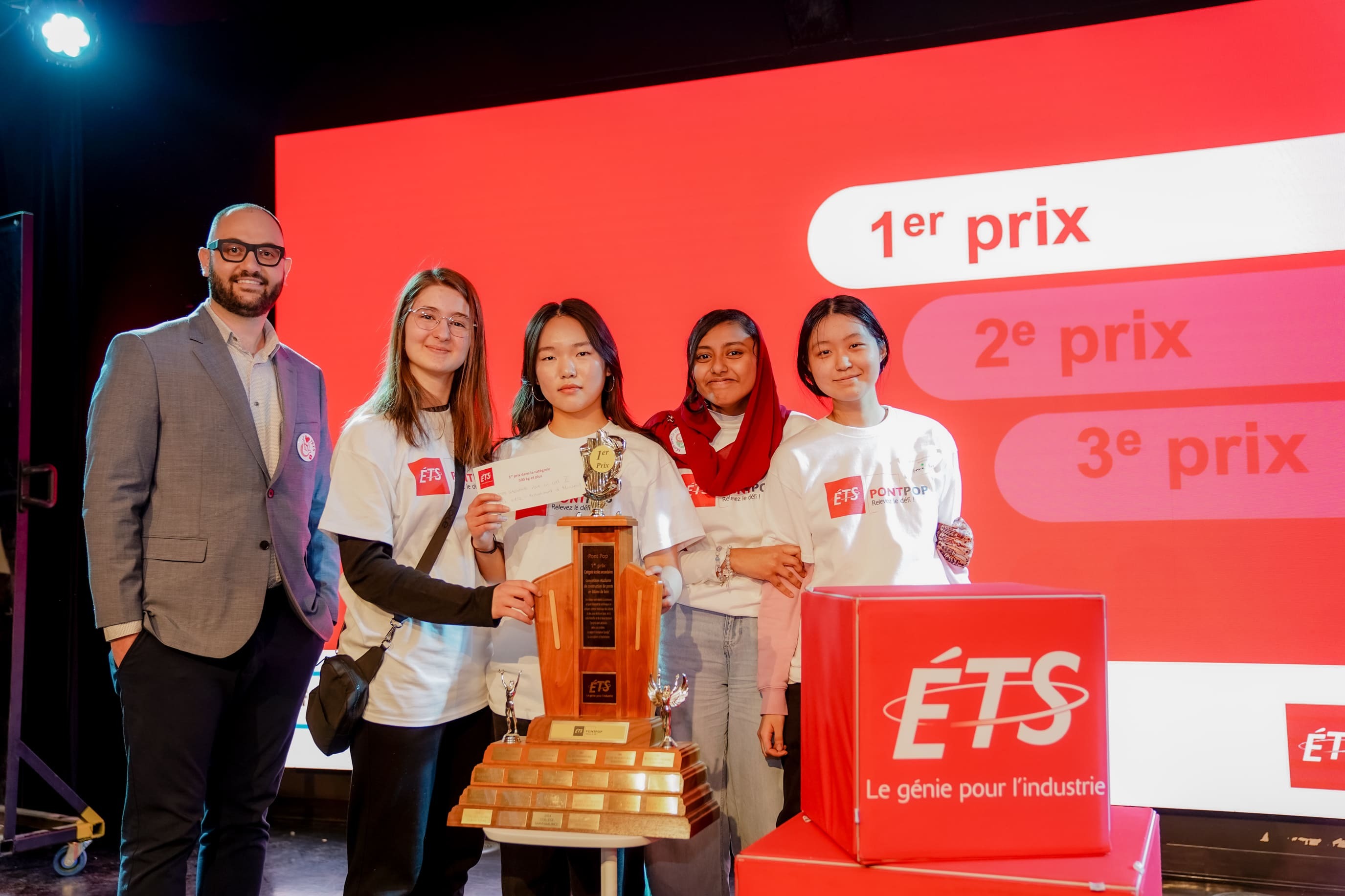 Des étudiantes de l'ETS célébrant leur victoire au concours, fières avec leur trophée et leur prix. Le génie au féminin !