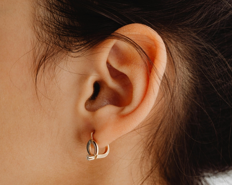 Une oreille délicate ornée d'un bijou élégant, mêlant modernité et simplicité dans un style raffiné.