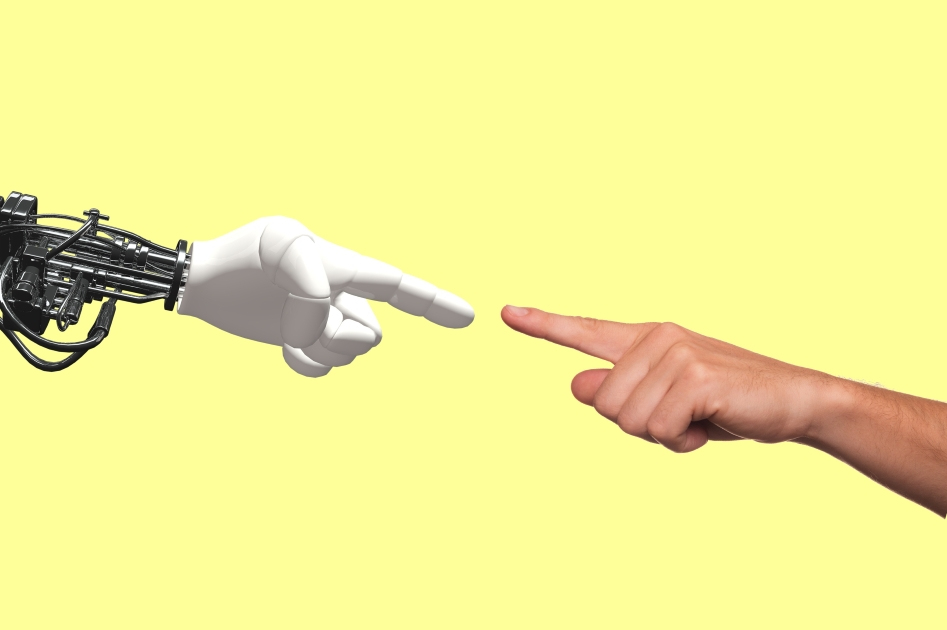 Une main humaine et un bras robotique se rapprochent, symbolisant l'interaction entre l'homme et la technologie.