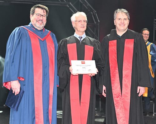 Faculty members in academic regalia celebrating a graduation ceremony.