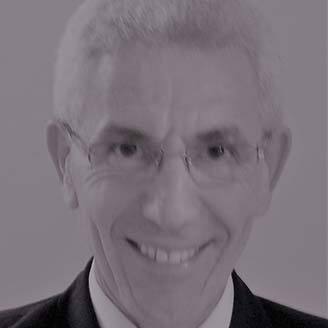 Professeur en technologie avec un sourire, habillé en costume formel.
