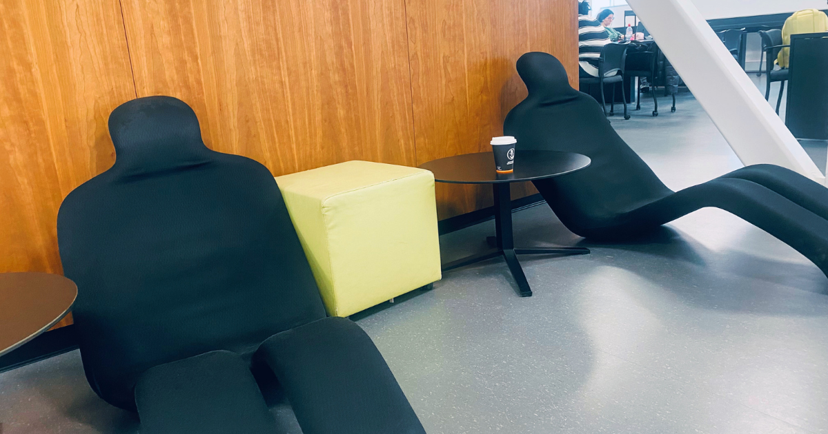 Espace détente moderne à l'université avec sièges ergonomiques et touches de couleur.