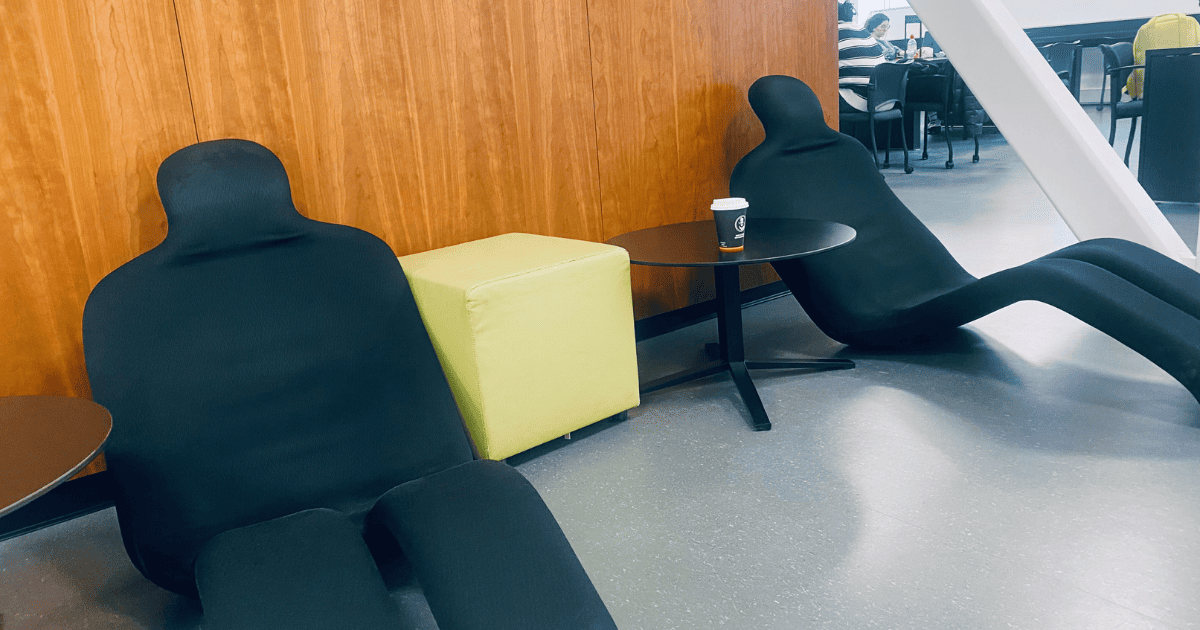 Espace détente moderne à l'université avec sièges ergonomiques et touches de couleur.