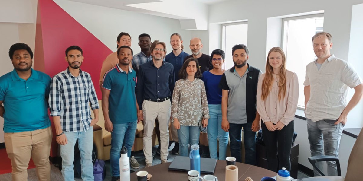 Groupe diversifié d'étudiants réunis dans un environnement académique, montrant camaraderie et collaboration.