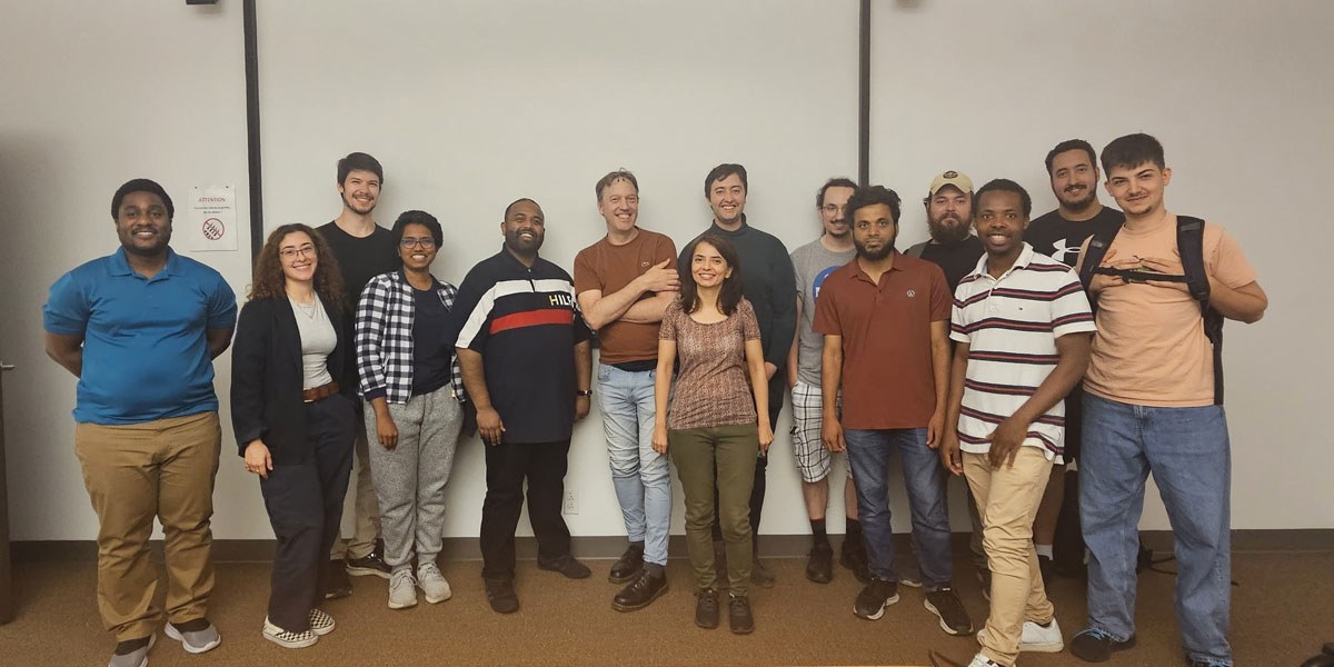 Un groupe diversifié d'étudiants souriants posant ensemble dans un environnement académique contemporain.
