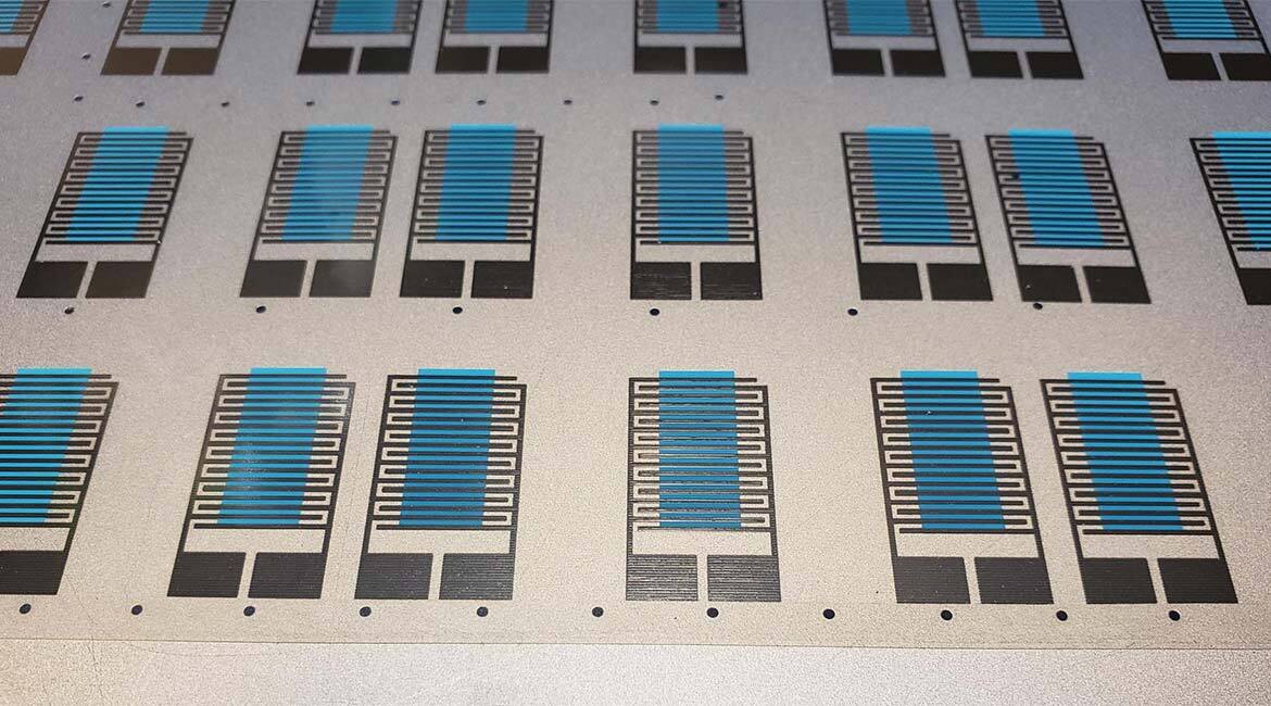 Électrodes conductrices en argent et matériau actif de détection (bleu) imprimés sur un substrat flexible