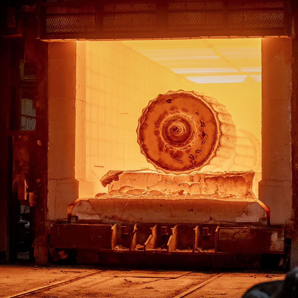 Un four industriel émet une lueur intense alors qu'un cylindre métallique est chauffé pour des processus de transformation.