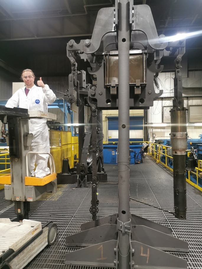 Un technicien guide une machine sophistiquée dans un environnement industriel, illustrant l'expertise en technologie avancée.