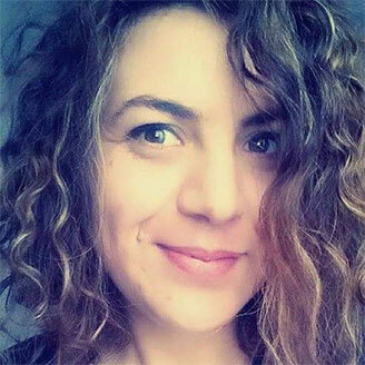 "University tech member with curly hair and a friendly smile."