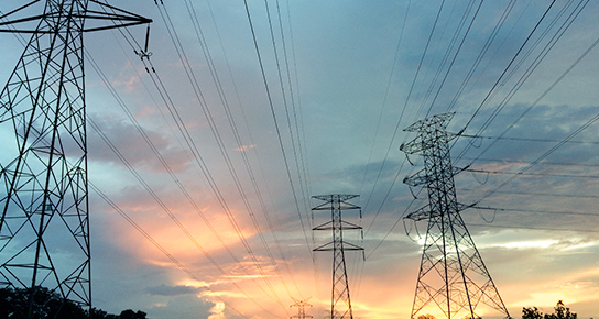 Pylônes électriques au coucher de soleil, symboles de la technologie et de l'énergie.