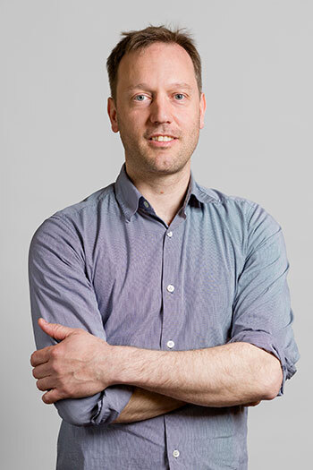 Confident professional in a blue shirt with arms crossed.