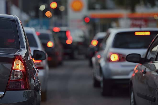 "Evening traffic with cars waiting at a red light, showcasing daily urban transportation issues."