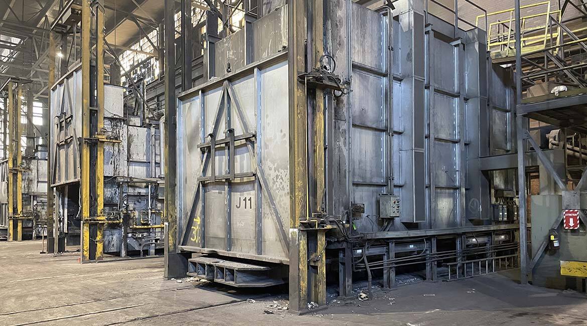 Atelier industriel avec équipements lourds et structures métalliques.
