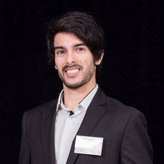 Jeune homme souriant en costume, représentatif d'un étudiant ou professionnel issu du domaine technologique supérieur.