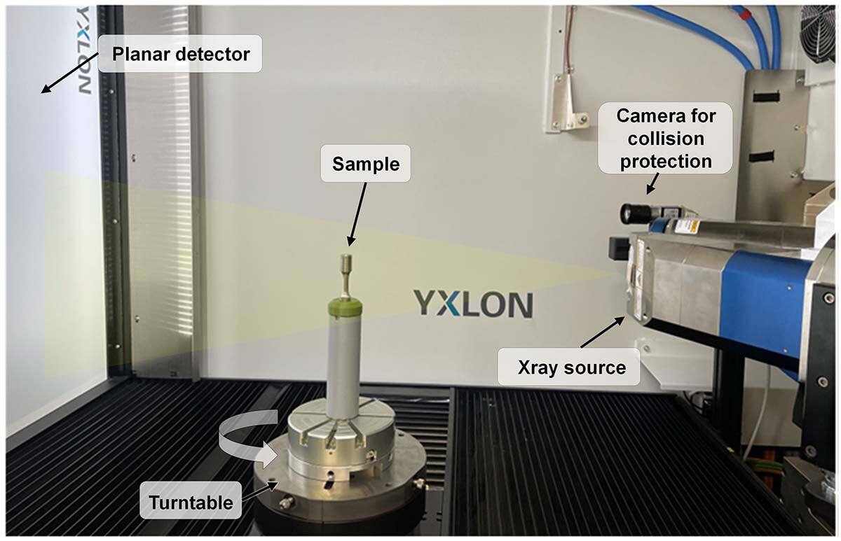 Advanced X-ray imaging system with sample on turntable, detectors, and safety camera.