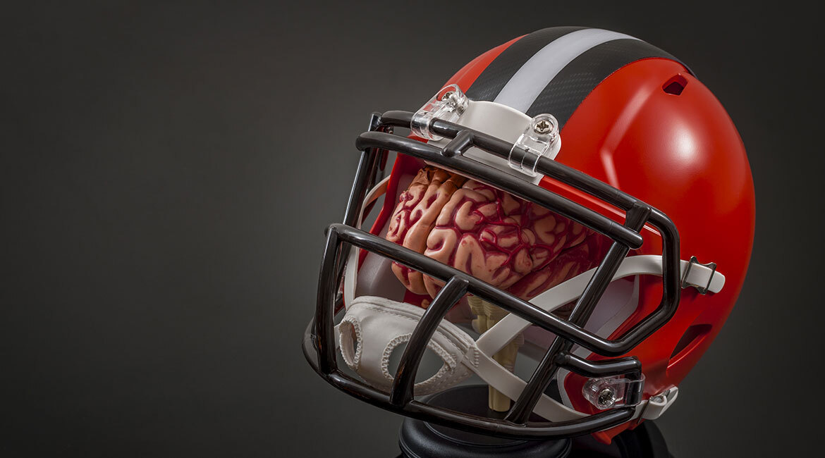 Casque de football avec cerveau, évoquant la sécurité et les neurosciences.