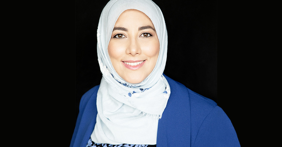 Fière étudiante en technologie avec un hijab, déterminée et souriante.