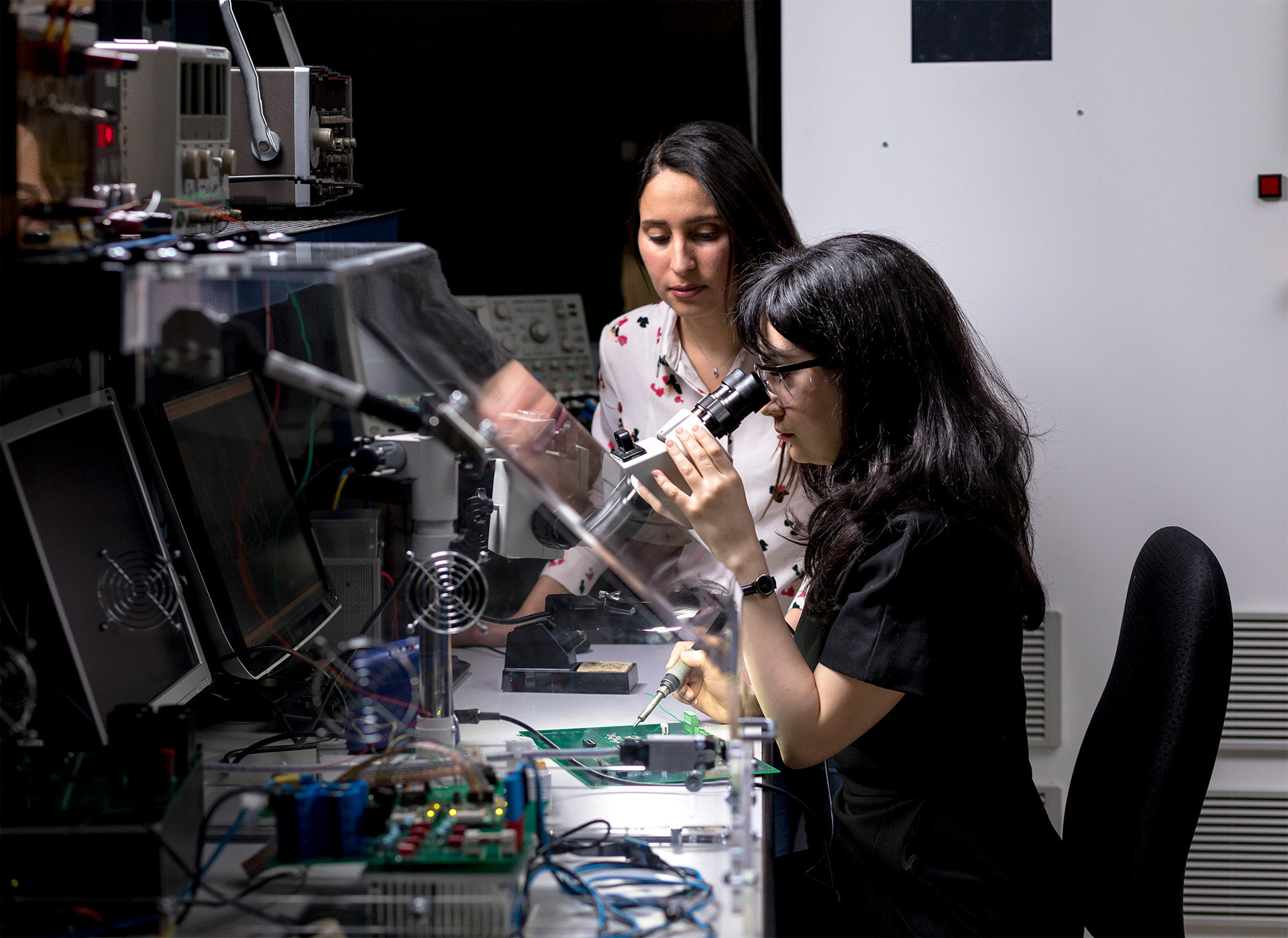 Étudiantes en laboratoire travaillant sur du matériel électronique de pointe.