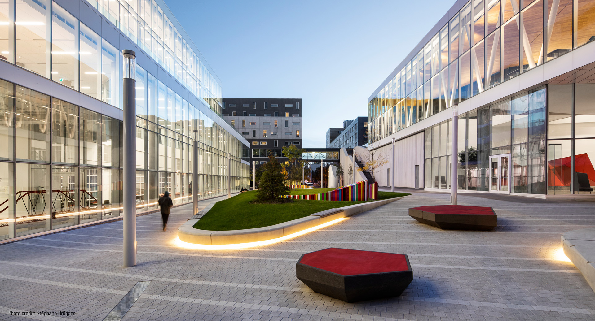 Campus moderne avec espaces verts et architecture contemporaine.