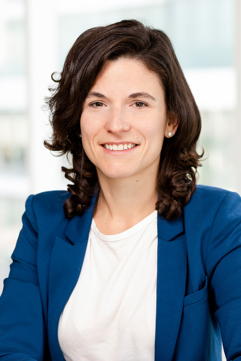 Professional with a welcoming smile, dressed in a blue blazer, embodies tech university's innovative spirit.