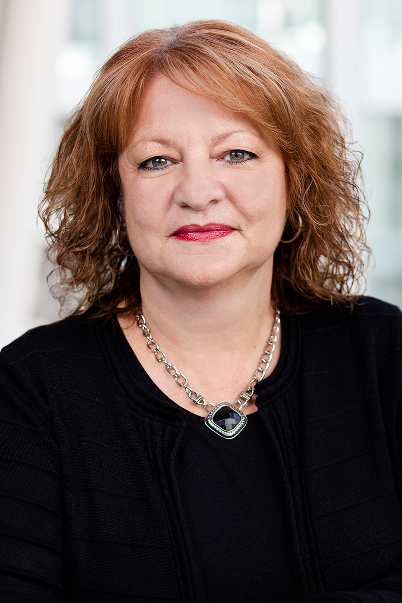 A university faculty member with experience and wisdom reflected in her confident gaze.