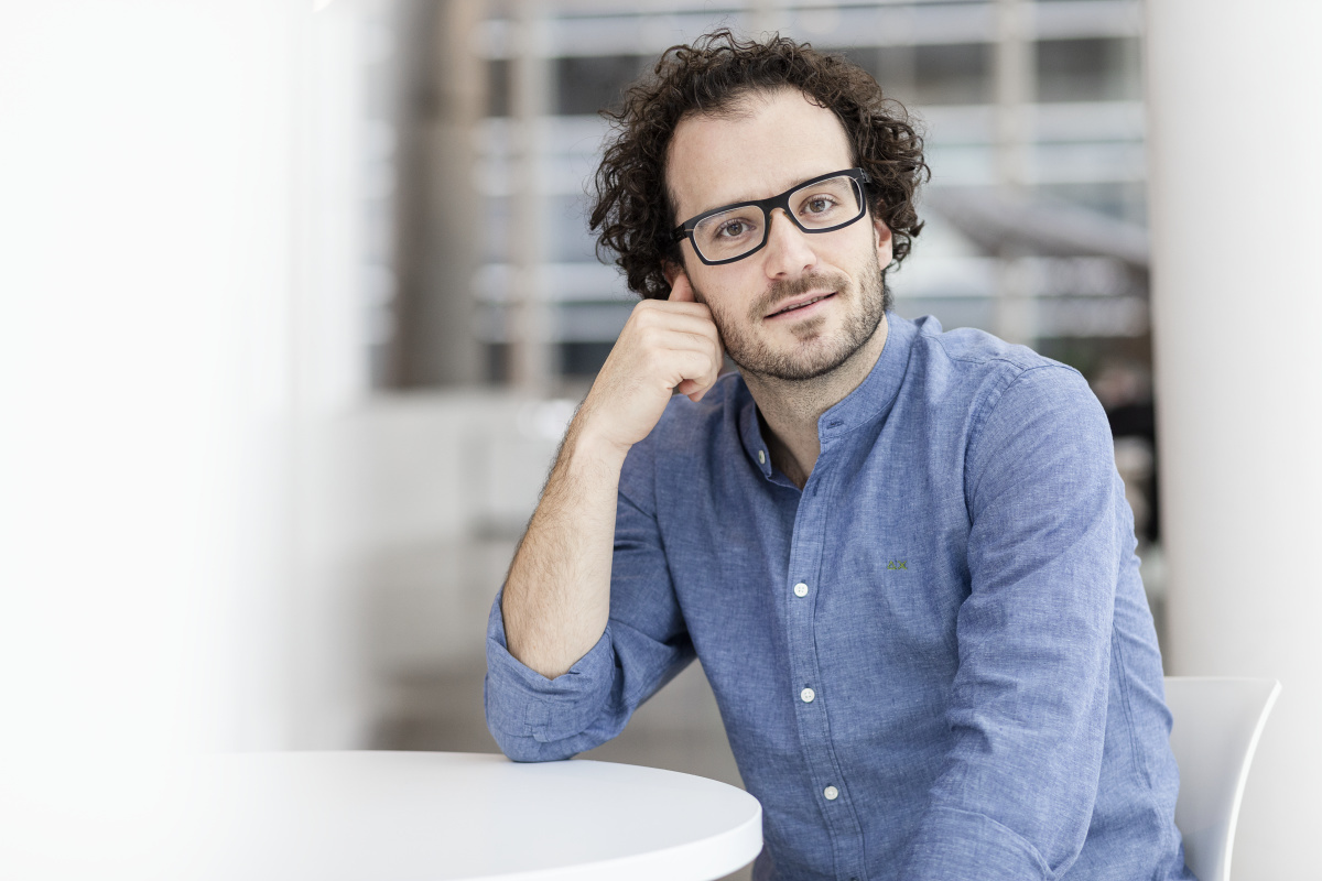 Étudiant concentré en pause, reflétant sur un projet technologique.