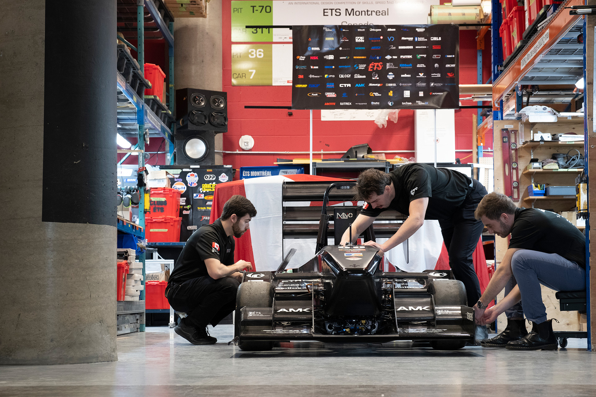 Étudiants en technologie travaillant sur une voiture de course à l'ÉTS Montréal.