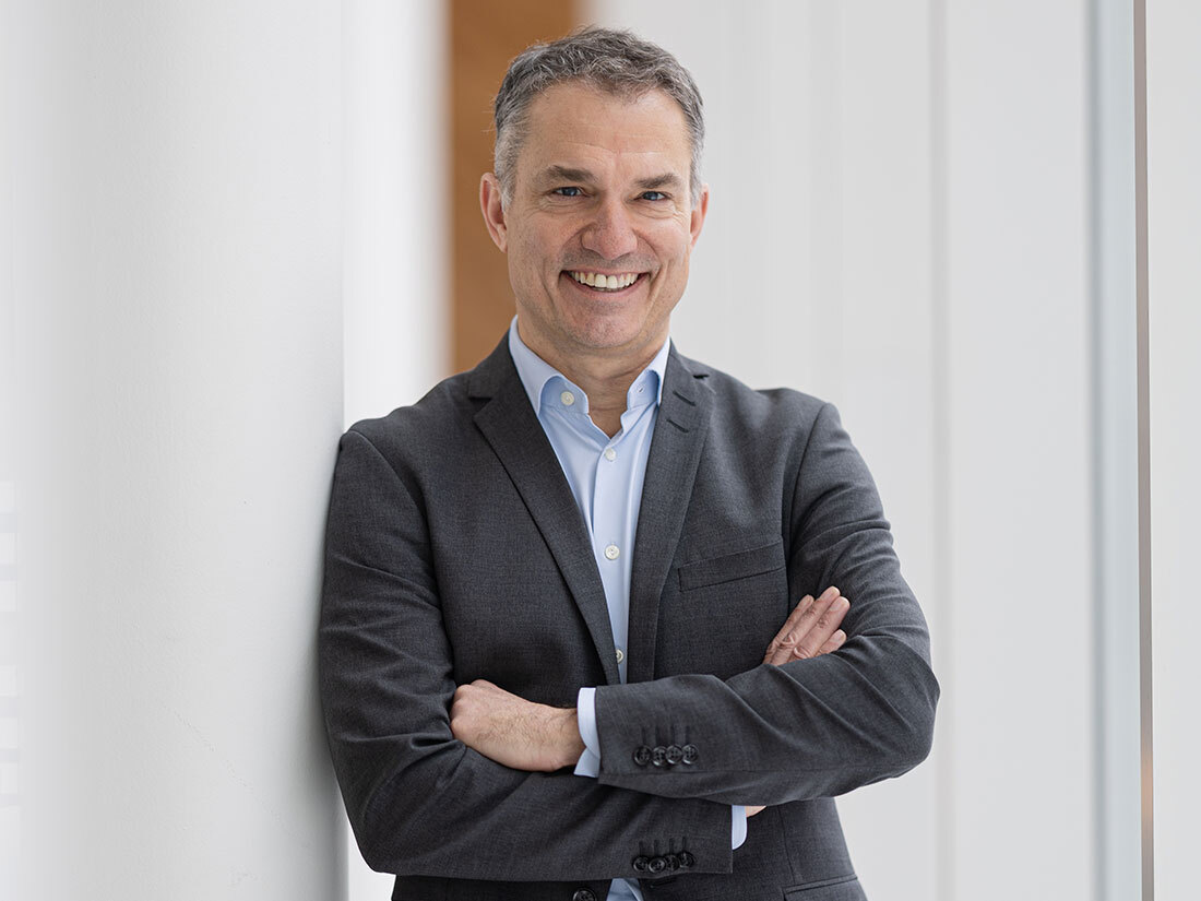 Professionnel souriant en costume, expert en technologie.