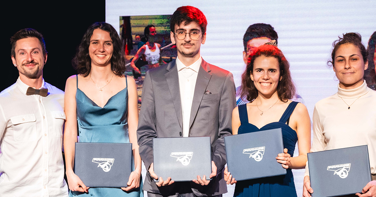 Diplômés souriants avec leurs certificats lors d'une cérémonie.