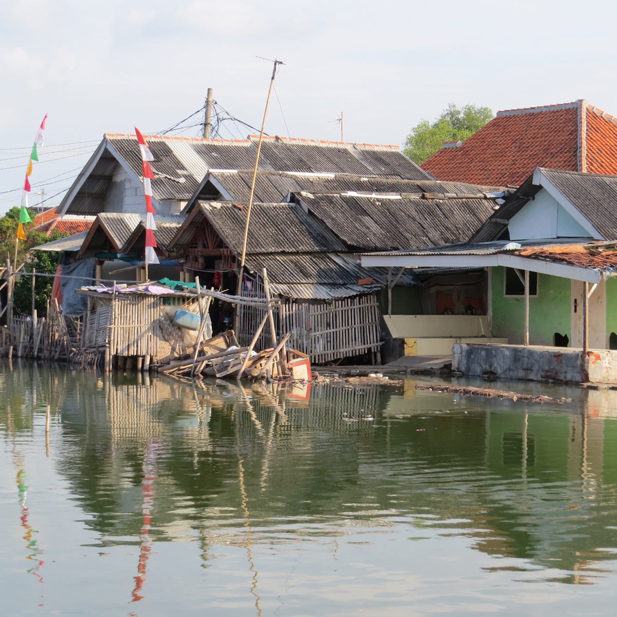 Un ensemble de maisons en bois au bord d'un cours d'eau, reflétant la vie traditionnelle et l'architecture locale.
