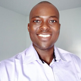 Confident male professional in a lavender shirt, showcasing charisma and a welcoming smile.