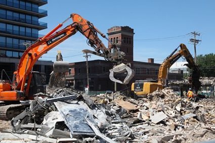 Une imposante grue trône au milieu d'un chantier. En arrière-plan, on aperçoit le quartier Griffintown et ses contrastes entre l'historique et le moderne.