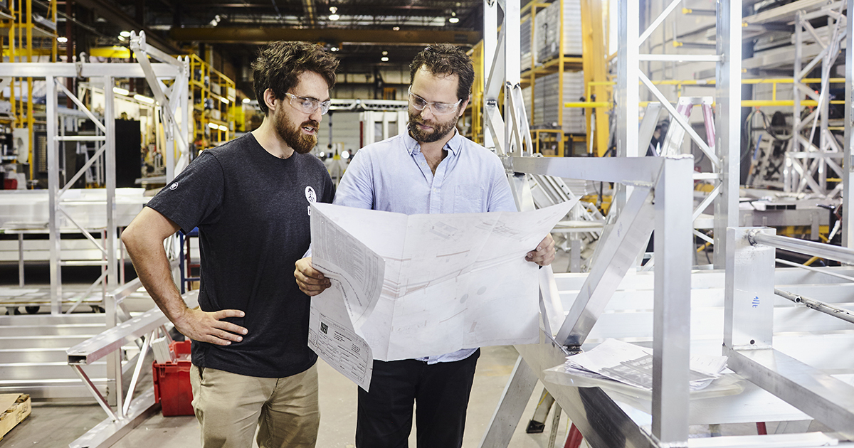 Des étudiants en technologie étudient des plans industriels.