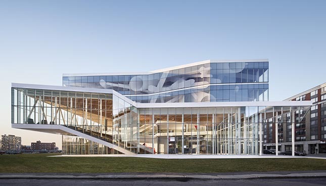 Architecture moderne avec façade en verre, reflétant le ciel. Design élégant et contemporain.