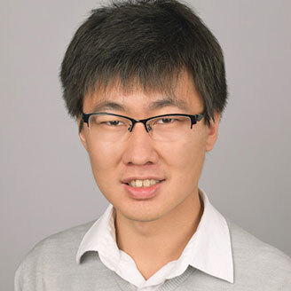 Faculty member in technology with glasses and a gentle smile.