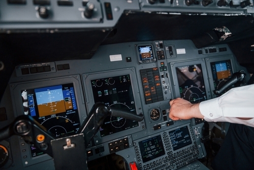 Main d'un pilote au travail sur le tableau de bord d'un avion. Préparation au décollage.