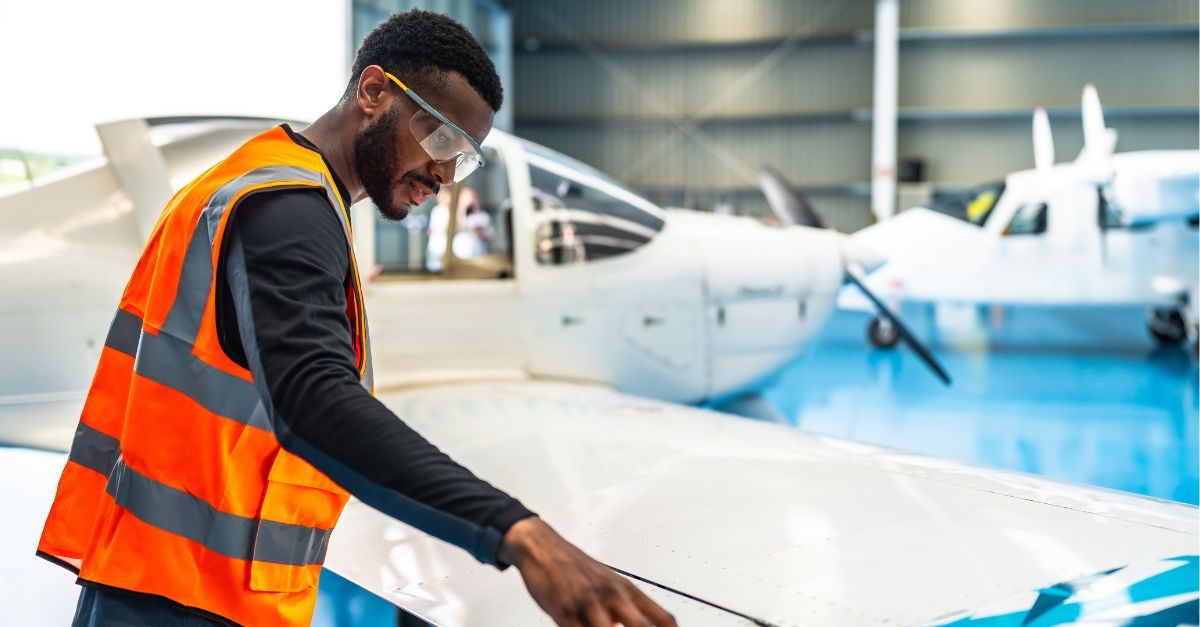 Un étudiant travaille minutieusement sur un aéronef, mettant en pratique ses compétences en ingénierie aéronautique.
