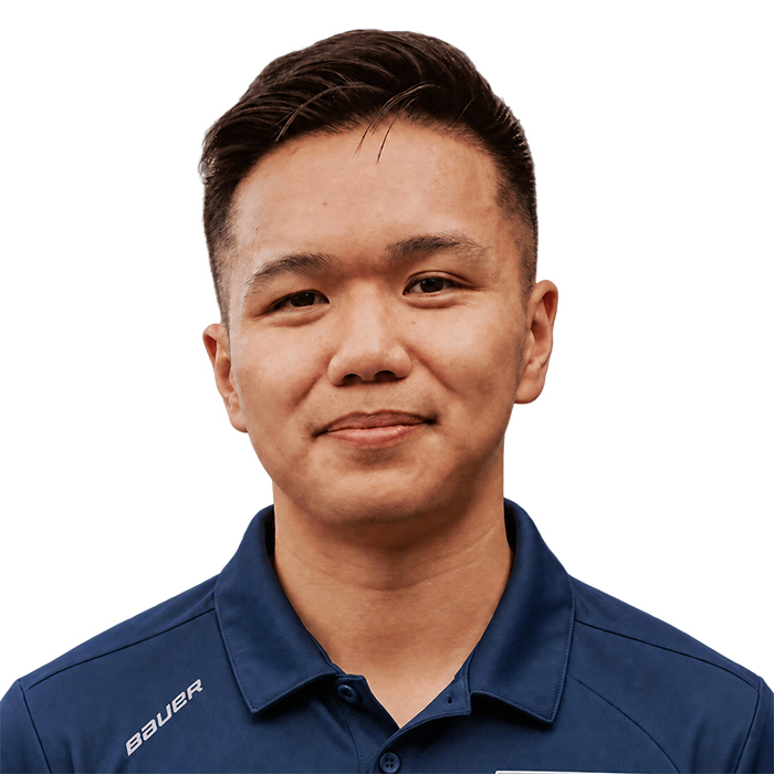 Portrait d'un étudiant souriant portant une chemise bleue, représentant l'esprit dynamique et accueillant de l'université.