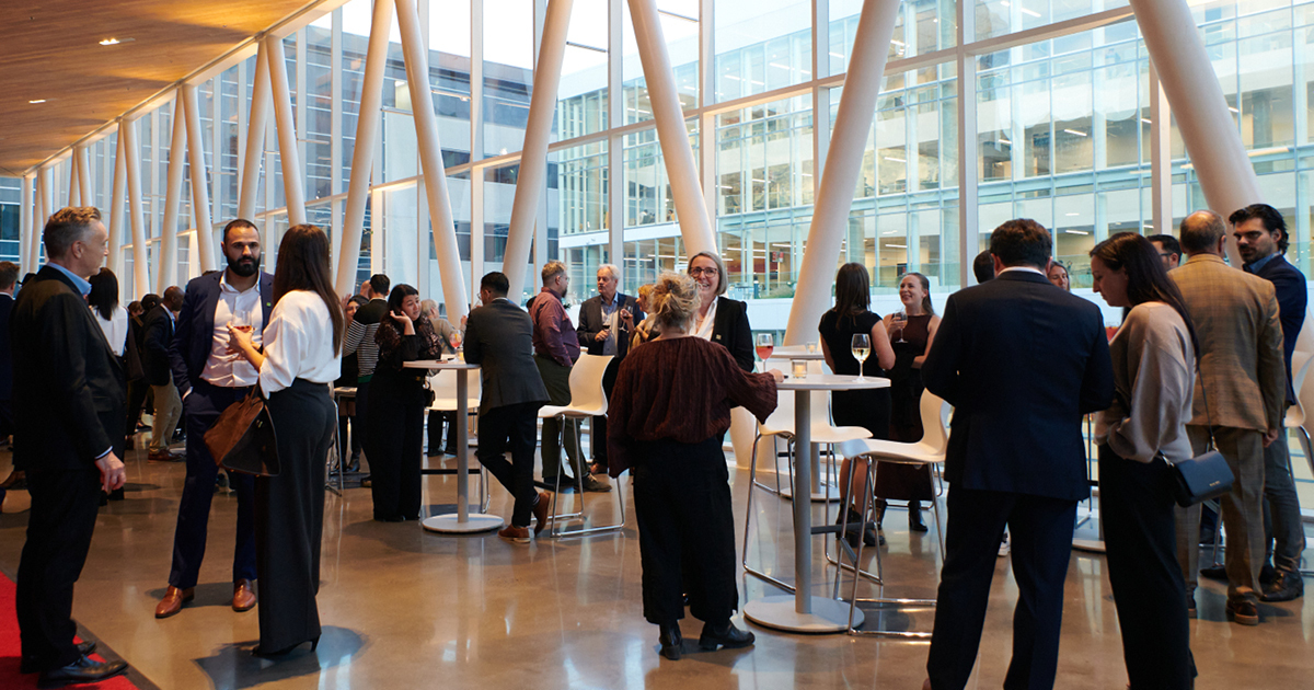 Rassemblement convivial dans un espace moderne, favorisant les échanges entre professionnels et étudiants autour d'un verre.
