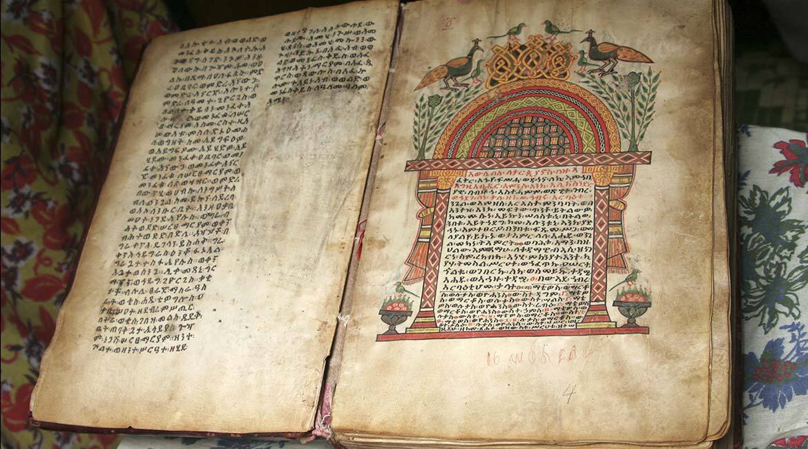 Manuscrit ancien avec enluminures et écriture exotique.