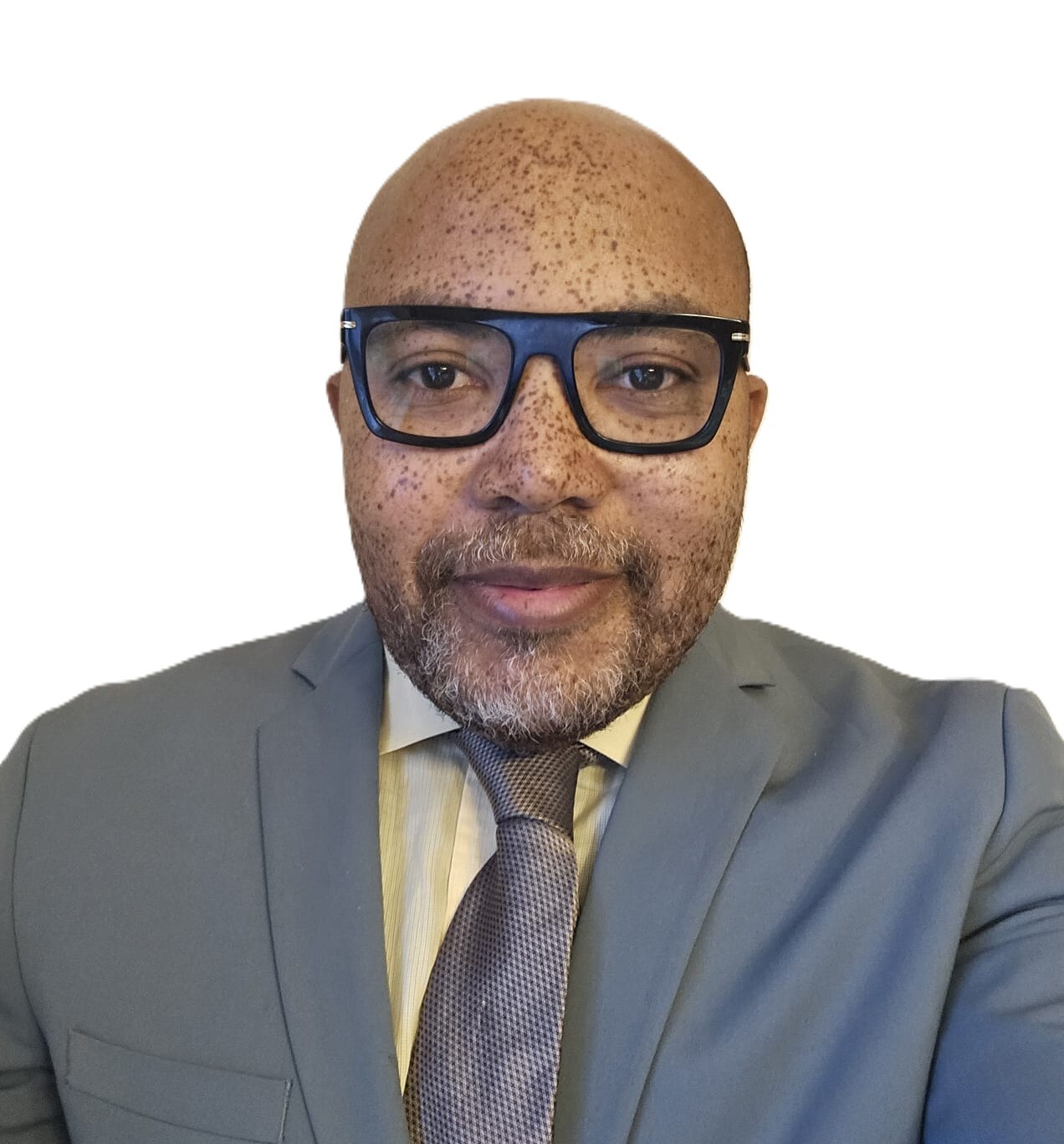Professionnel en tenue formelle, il affiche un sourire confiant, portant des lunettes et bien coiffé, avec un style soigné.
