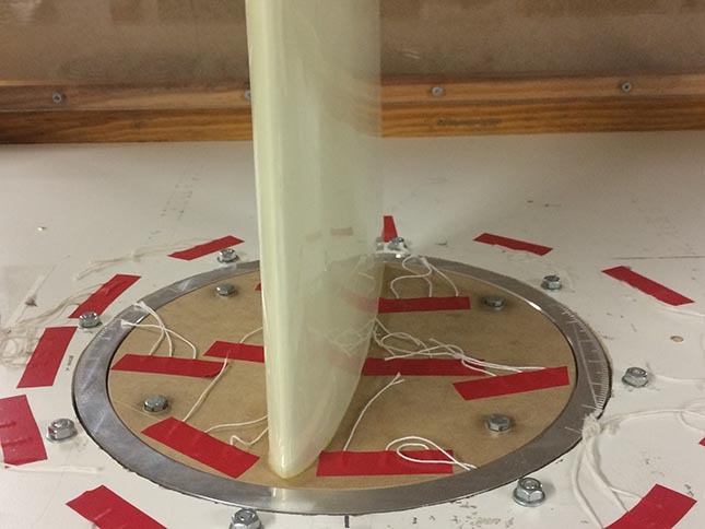 Dispositif expérimental avec cylindre central, base graduée et connexions électriques.