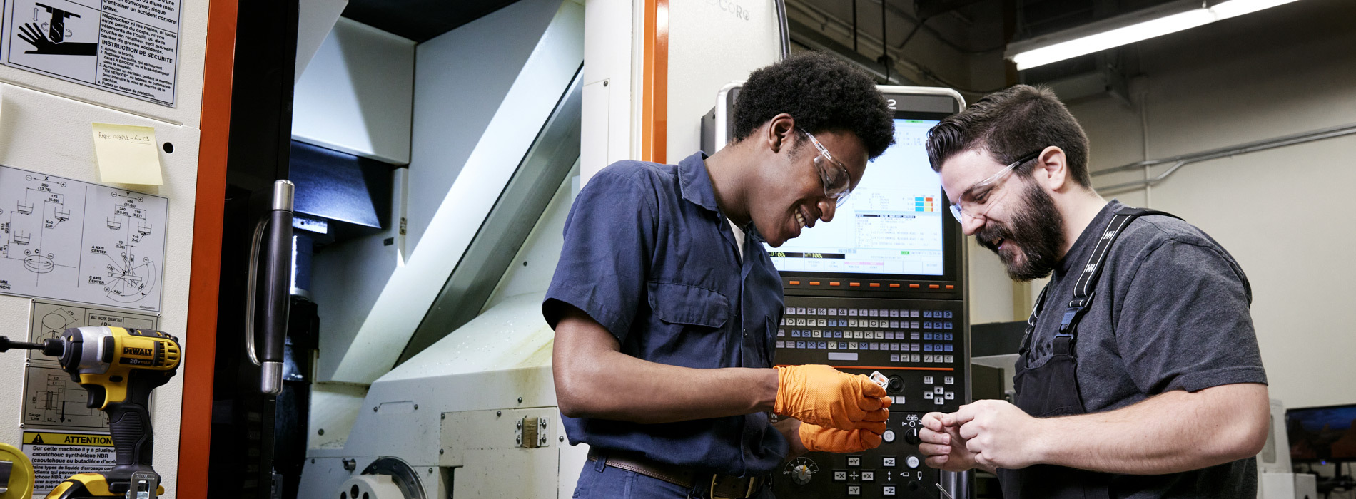 Students collaborate in a workshop, engaging with machinery and tools while learning practical skills in a technology-focused environment.