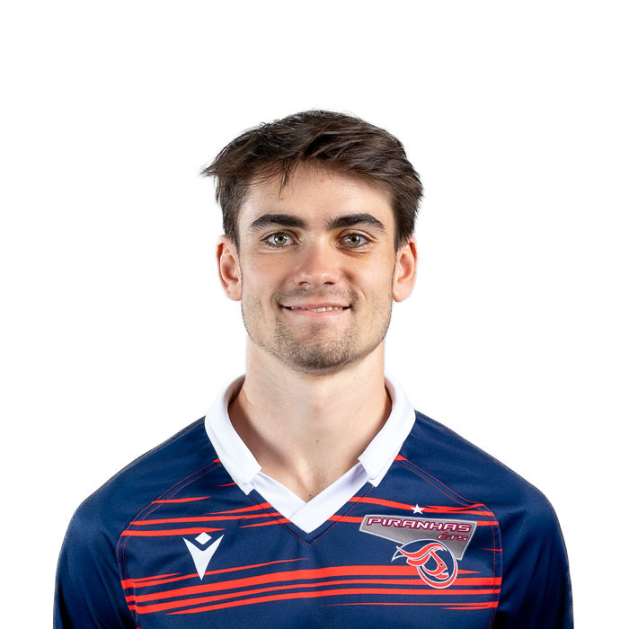Étudiant dynamique en technologie, représentant des Piranhas, sourire confiant et déterminé dans un maillot aux couleurs vives.
